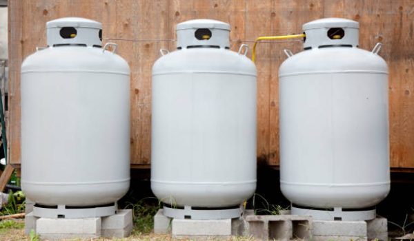 Side and front views of three gray freshly painted propane tanks. Horizontal.